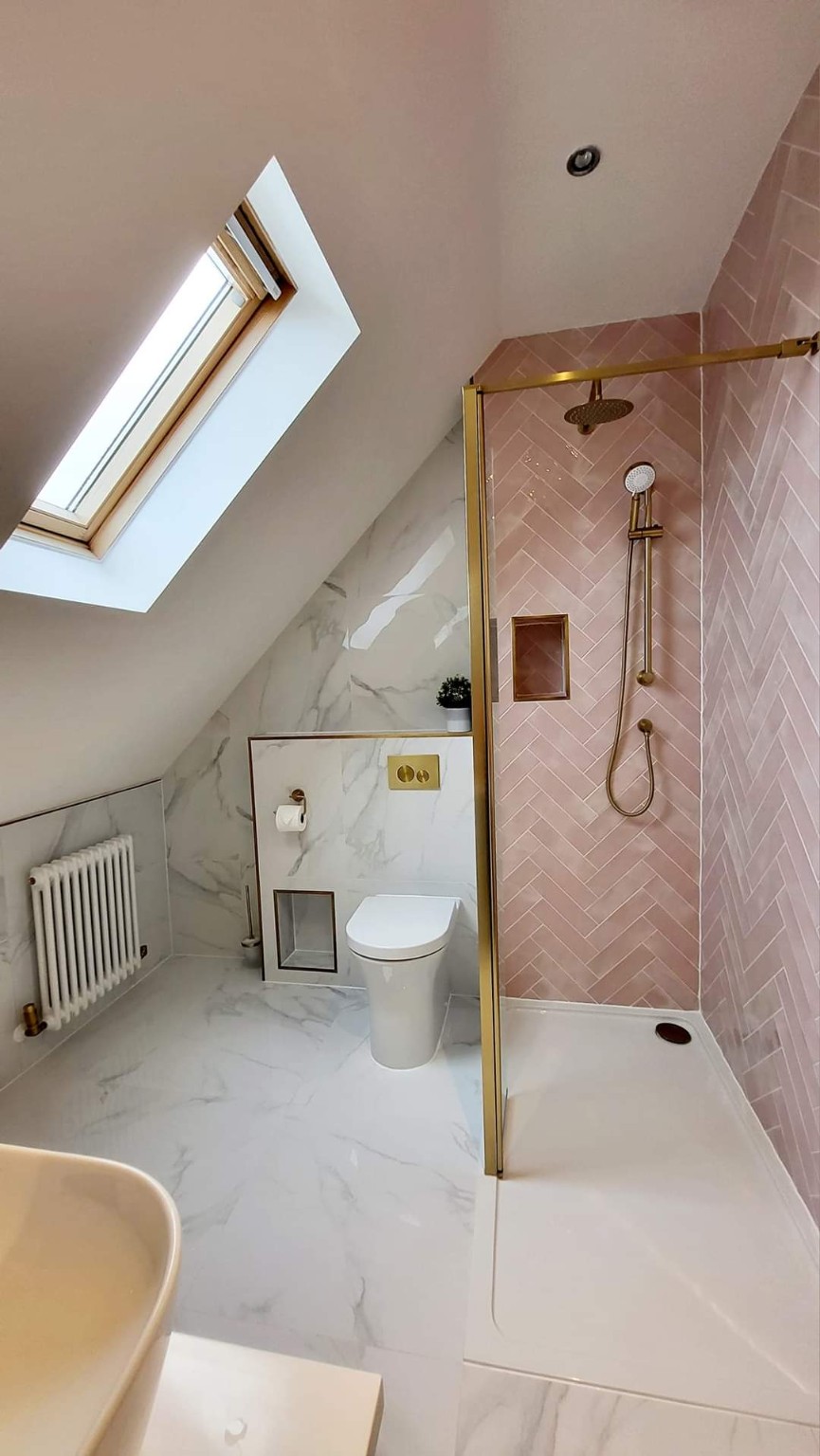 Completed shower room with rose herringbone tiles and warm brass finishes